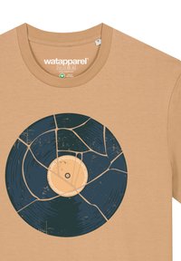 Tan katoenen t-shirt met een grafisch ontwerp van een gebroken vinylplaat in donkerblauw en beige tinten, met ingewikkelde details en textuur.
