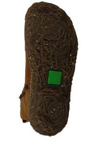 Suela de zapato de cuero marrón con una suela de goma marrón texturizada que presenta un patrón que recuerda a la paja. Incluye un logo de rana verde.