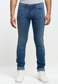 Modré džíny z denimu s úzkým střihem, pěti kapsami, poutky na opasek a rovnýma nohama. Džíny mají mírné obarvení a ohrnuté manžety.