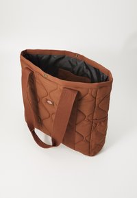 Több rétegű, barna táska két strapabíró textil fülekkel, belső zsebbel és sima, kontrasztos sötét bélésével.