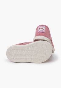 Scarpe in tela rosa con suola in gomma bianca. Presentano un tessuto morbido, una punta tonda e un'etichetta con un design di scimmia cucita sul tallone.