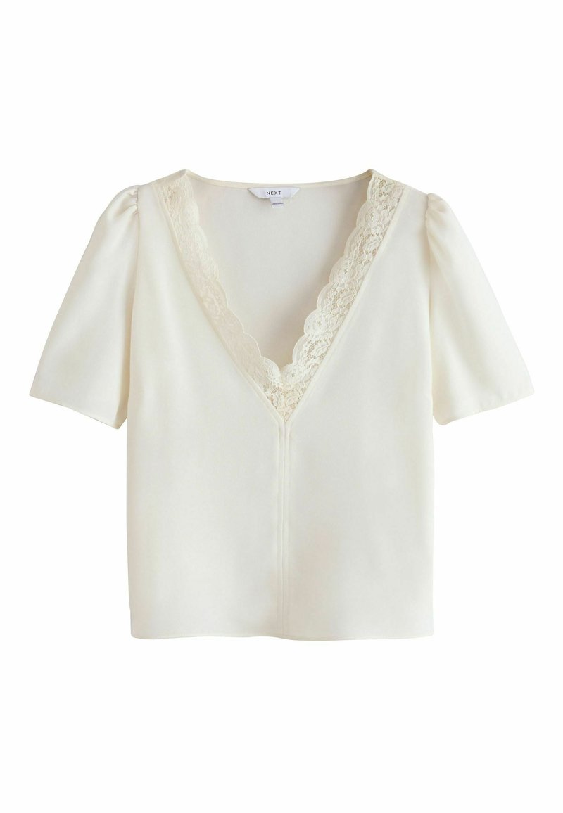 Weiße Bluse mit kurzen Ärmeln und V-Ausschnitt. Verfügt über einen Spitzenbesatz am Hals und eine leicht taillierte Silhouette. Glatter, leichter Stoff.