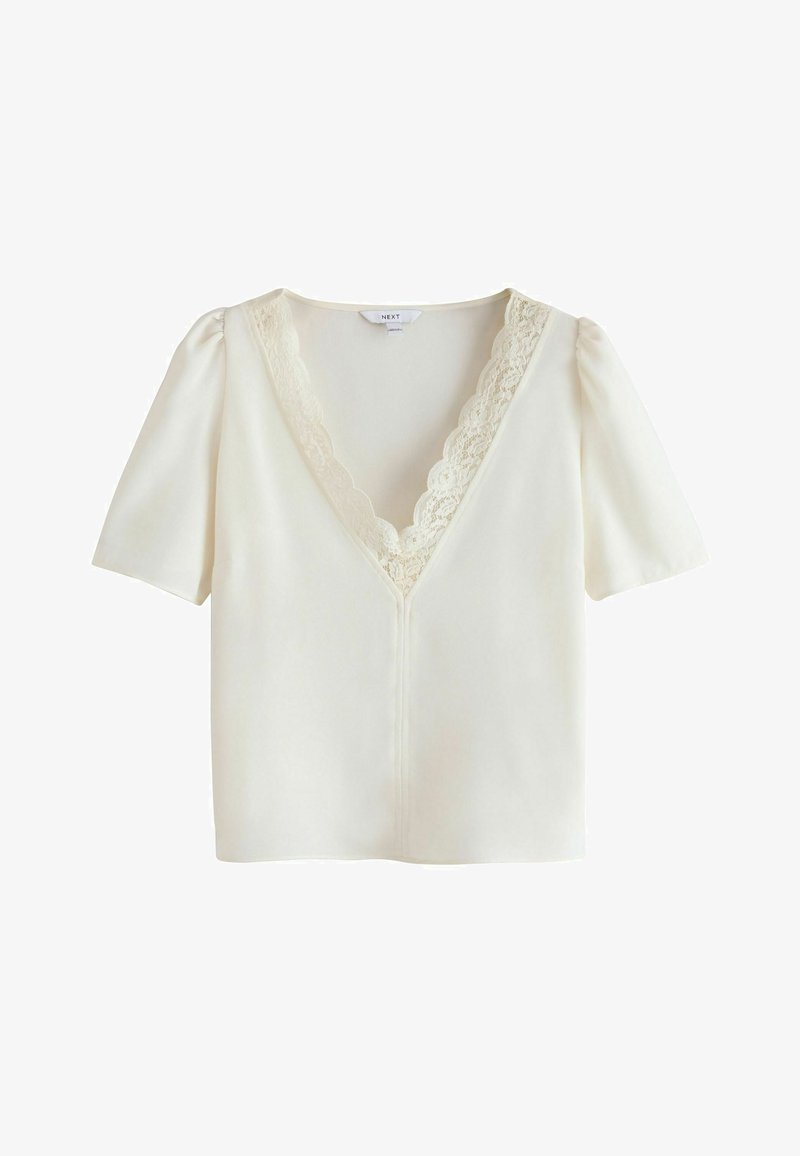 Short-sleeve white blouse with a V-neckline. Features lace trim around the neck and a slightly fitted silhouette. Smooth, lightweight fabric.