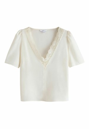 Lühikesleeve valge bluus, millel on V-kujuline kaelus. Kaelas on pitsääris ja veidi istuv siluett. Sile ja kerge kangas.