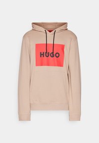 Sudadera con capucha en beige claro con un cuadrado rojo en el frontal que presenta "HUGO" en letras negras en negrita. Incluye un bolsillo canguro y cordones negros.