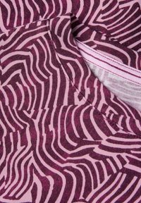 Violetti kangas, jossa on seeprahaitakuvio vaaleanpunaisen ja tumman violetin sävyissä, pehmeä rakenne, sileä sauma ja pyöreä pääntie.