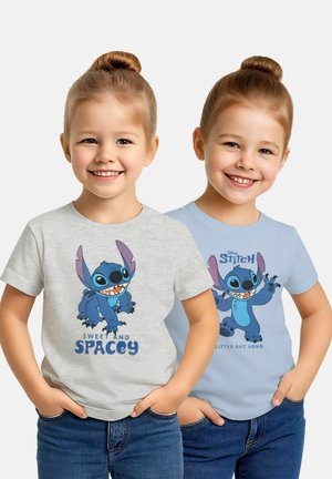 Due ragazze sorridenti con capelli raccolti in chignon, indossano jeans e magliette Disney Stitch, una grigia con la scritta "Sweet and Spacey" e l'altra blu con la scritta "Little But Loud".