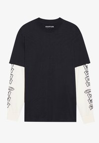 Crni kratki rukavi T-shirt s dugim bijelim rukavima. Bijeli rukavi koriste crne grafičke tekstualne dizajne. Pamuk s opuštenim krojem.