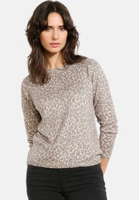 Sweter w deseń lamparta wykonany z miękkiego materiału, z długimi rękawami i okrągłym dekoltem. Kolory obejmują beżowy i szary z teksturowanym wzorem.