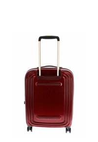 Czerwona twarda walizka z błyszczącym wykończeniem, teksturowanymi rowkami, teleskopową rączką oraz czterema czarnymi kółkami do łatwego transportu.