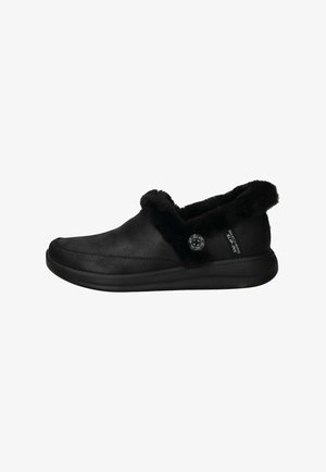 Chaussures noires à enfiler en cuir lisse avec un col en fausse fourrure doux, un design courbé et un accent de bouton décoratif sur le côté.