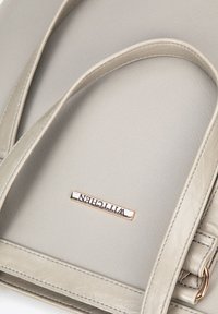 Borsa tote sintetica grigia con doppie maniglie, texture liscia, dotata di una placca con logo in oro e dettagli di cucitura sui bordi.