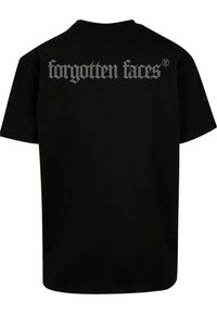 Černé bavlněné tričko s krátkými rukávy. Na zadní straně se nachází velký nápis "zapomenuté tváře" v stříbrném metalickém tisku. Základní design s kulatým výstřihem.