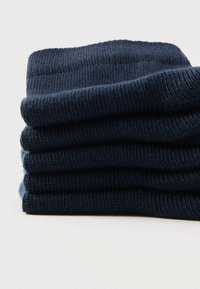 Σκουρομπλε βαμβακερές κάλτσες στοιβαγμένες προσεκτικά, με ριμπ ύφανση και ομαλή επιφάνεια. Κάθε κάλτσα έχει ίσο μήκος και πλάτος.