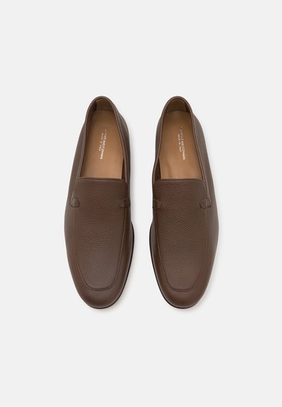 Mocassins en cuir marron avec une finition texturée et un bout lisse. La doublure intérieure est de couleur marron clair. Design minimaliste sans lacets ni éléments métalliques.