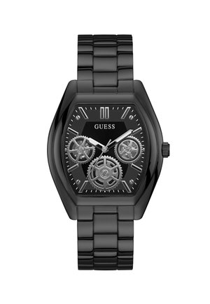 Zwarte metalen horloge met octagonaal kast, transparante tandwielen, zwarte wijzerplaat, zilveren accenten en een schakelsband. Merkennaam "GUESS" weergegeven.