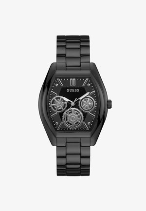 Zwarte metalen horloge met octagonaal kast, transparante tandwielen, zwarte wijzerplaat, zilveren accenten en een schakelsband. Merkennaam "GUESS" weergegeven.