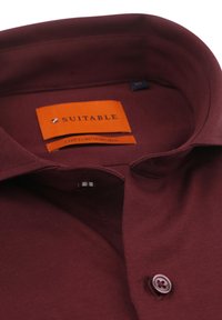 Bordeaux katoenen shirt met een puntige kraag, met een oranje label. Inclusief een enkele donkere knoop en een gladde, gestructureerde stof.