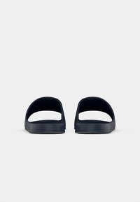 Navy slide sandals with a minimalist design, made of smooth material, featuring two wide open straps and a flat sole for easy wear.