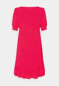 Czerwona sukienka w białe kropki z krótkimi bufkami, okrągłym dekoltem i falbaniastym dołem. Wykonana z lekkiego materiału z białymi plamkami.