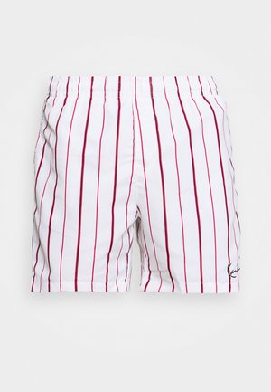 Weiße Shorts mit vertikalen roten Streifen und elastischem Bund, mit kleinem schwarzem Signaturlogo am unteren rechten Saum.