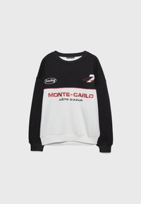 Zwart-witte sweatshirt met de tekst "MONTE-CARLO CÔTE D'AZUR" in rode borduurwerk, voorzien van een ronde hals en geribbelde manchetten. Met racelogo als accent.