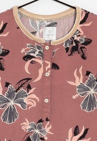 Blumenbluse in staubrosa mit schwarzem und pinkem Blumenmuster. Weicher Stoff, runder Halsausschnitt mit beiger Einfassung und drei Knöpfen vorne.