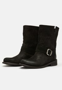 Black suede ankle boots with a textured design, a flat heel, and a decorative strap featuring a metal buckle. Two side openings for easy wear.