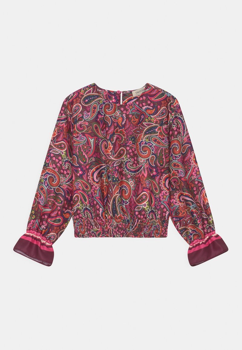 Blouse à manches longues avec taille et poignets élastiques, présentant un motif cachemire vibrant rose et orange, et une fermeture à boutons dans le dos.