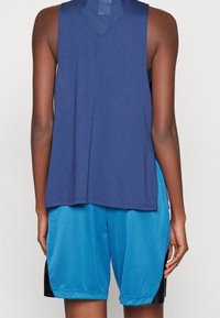 Granatowy top bez rękawów z teksturowanym tyłem, zestawiony z jasnoniebieskimi szortami do koszykówki z siateczkowym wzorem i czarnymi bocznymi akcentami.