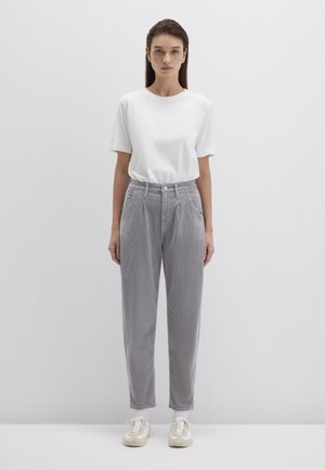 White short-sleeve t-shirt paired with light gray, textured high-waisted trousers and beige sneakers, set against a plain background.