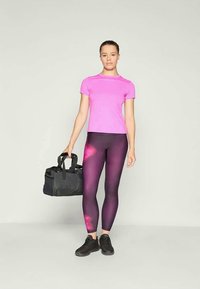Tricou sportiv roz, stil ajustat; colanți mov cu un model gradient; geantă sport neagră; adidași negri; material neted, elastic.