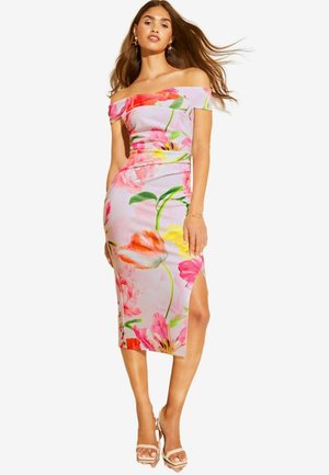 Abito floreale senza spalle in rosa chiaro, con grandi motivi di fiori rosa, gialli e verdi; silhouette aderente con spacco laterale.