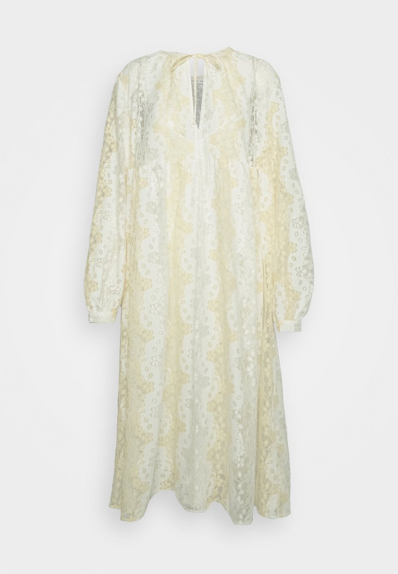 Leichtes, hellgelbes und cremefarbenes Kleid mit Spitze, locker sitzend, langen Ärmeln und einem Schlüssellochausschnitt, mit floralem Muster.