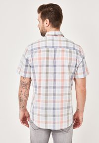 Kurzärmliges Karohemd in Weiß, Grau, Blau und Koralle. Mit klassischem Kragen, Rückenpasse und abgerundetem Saum. Weicher Stoff.