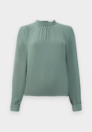 Prachovo zelená blúzka s dlhým rukávom, s r gathered mock neck a manžetami, vyrobená z ľahkej texturovanej látky.