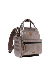 Metallisch roségoldener Rucksack mit strukturierter Form, doppelten Griffen, verstellbaren Trägern, frontalem Reißverschlussfach und kreisförmigem Logodetail.