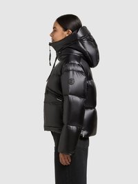 Zwarte gewatteerde jas met een hoge kraag en een capuchon. Voorzien van ritszakken en een glanzende afwerking. Geribbelde manchetten en logo-accent.