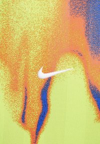 Odzież sportowa Nike z żywym, teksturowanym materiałem w gradientzie żółtego, pomarańczowego i niebieskiego, z białym logo Swoosh.