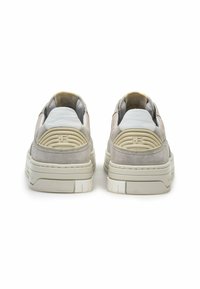 Sneaker in suede grigio con dettagli in pelle bianca, suola spessa color crema, logo in rilievo sul tallone e collarino imbottito per maggiore comfort.