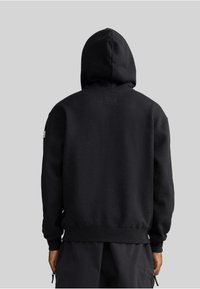 Felpa con cappuccio nera realizzata in misto cotone. Presenta una tasca a marsupio, polsini a costine e orlo piatto. Design semplice e senza fronzoli.