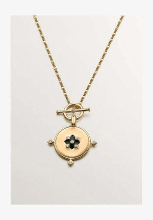 Collar de cadena dorada con colgante redondo que presenta un diseño negro de cuatro pétalos y pequeños acentos de diamantes en los bordes y el centro.