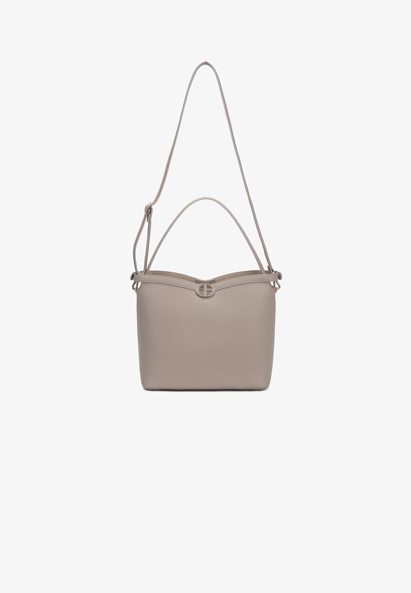 Sac à main beige avec une texture en cuir lisse, forme rectangulaire et sommet arqué. Il possède une bandoulière plate et un accent en métal circulaire.