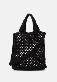 Sort strikket tote taske med et åbent gitterdesign, dobbelte håndtag og en aftagelig skulderrem. Fleksibelt materiale forbedrer teksturen.