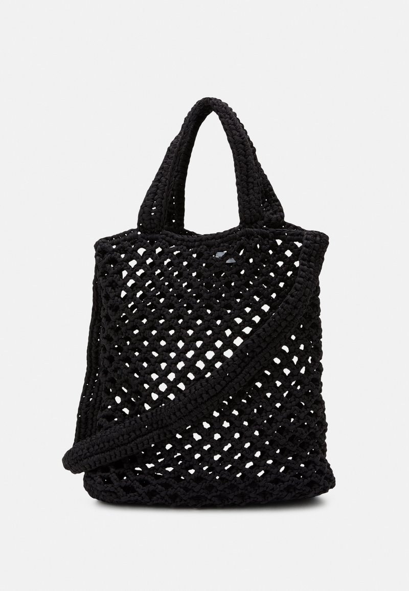 Sort strikket tote taske med et åbent gitterdesign, dobbelte håndtag og en aftagelig skulderrem. Fleksibelt materiale forbedrer teksturen.