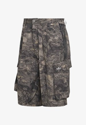 Βερμούδα cargo με σχέδιο παραλλαγής και πλαϊνή τσέπη που φέρει το λογότυπο trefoil της Adidas και τρεις μαύρες ρίγες κατά μήκος της ραφής της τσέπης.