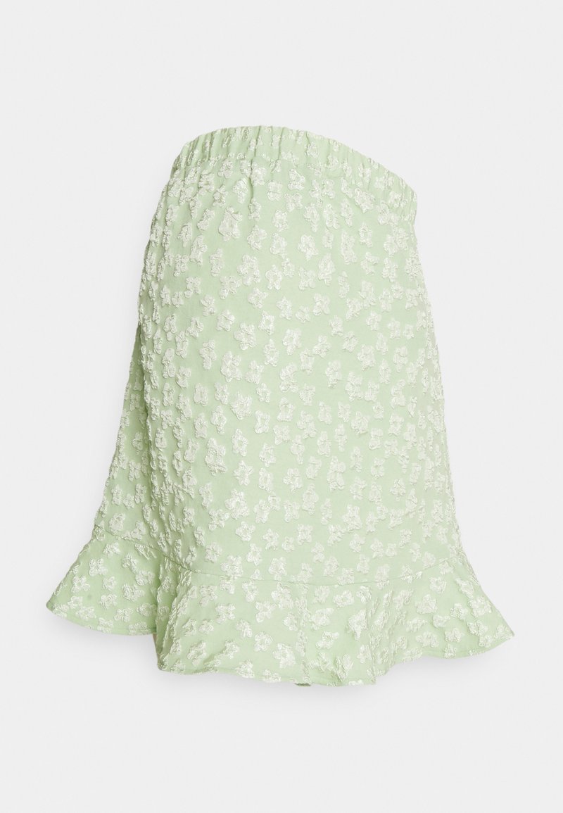 Saia floral verde com um padrão texturizado, cintura elástica e bainha em babados. Apresenta pequenas flores brancas por todo o tecido.