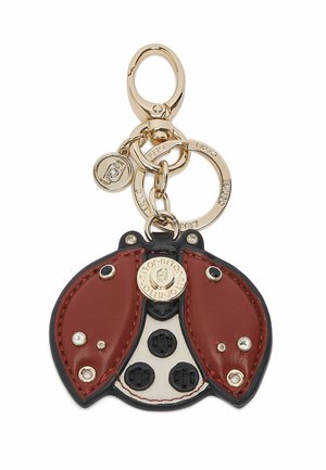 Gouden metalen sleutelhanger met een leren bedel in de vorm van een lieveheersbeestje in rood, wit en zwart, versierd met kleine kristallen en gebrande metalen labels.