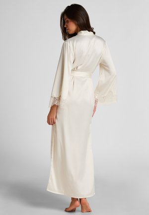 Lange, crèmekleurige satijnen badjas met kanten accenten op de mouwen, voorzien van een gestrikte taille en een vloeiende silhouet. Soepele textuur en een comfortabele pasvorm.