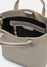 Sac fourre-tout en cuir gris avec une texture lisse, poche intérieure zippée et détails de logo. Doté de poignées robustes pour le transport.